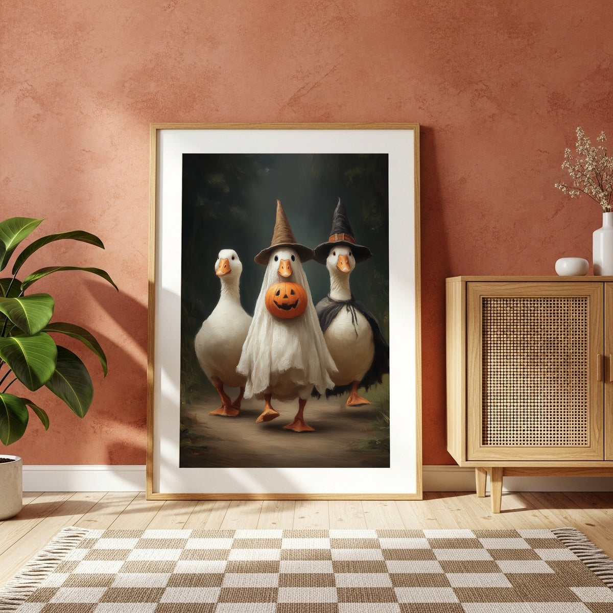 Halloween geese maximalist print displayed in a light wood frame against a warm terracotta wall