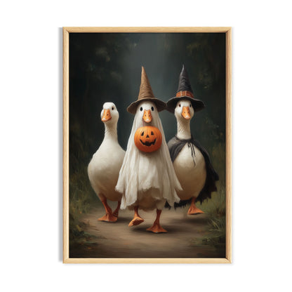 Three funny white geese in Halloween costumes with witch hats, a ghost costume and jack-o'-lantern pumpkin