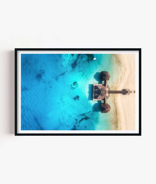Bring bright coastal escape style to your space with this tropical beach resort print, featuring turquoise ocean water, soft white sand, overwater huts and a peaceful aerial island view for bedrooms, bathrooms, living rooms, offices, holiday homes and gallery walls.