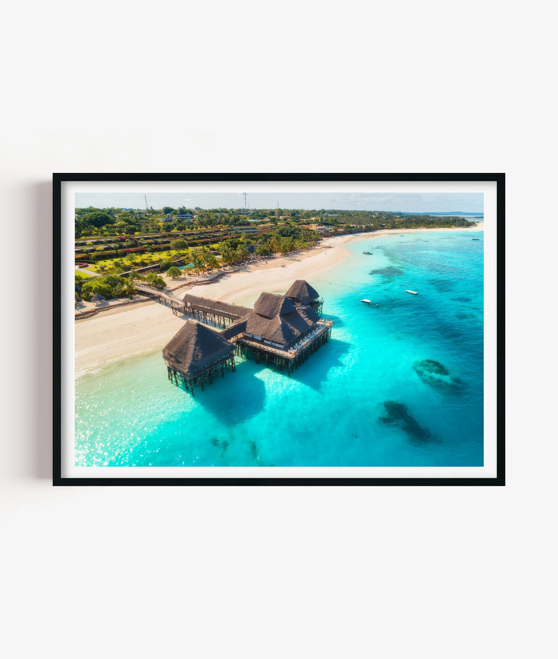 Bring bright tropical escape style to your space with this island beach resort print, featuring clear turquoise water, white sandy shoreline, palm trees and overwater huts in a sunny coastal scene for bedrooms, bathrooms, living rooms, offices, holiday homes and gallery walls