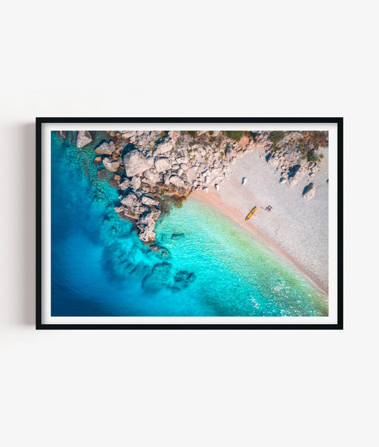 Bring fresh coastal escape style to your space with this rocky cove beach print, featuring clear turquoise water, soft sandy shoreline, natural stone rocks and a peaceful aerial seaside view for bathrooms, bedrooms, living rooms, offices, beach houses and gallery walls.