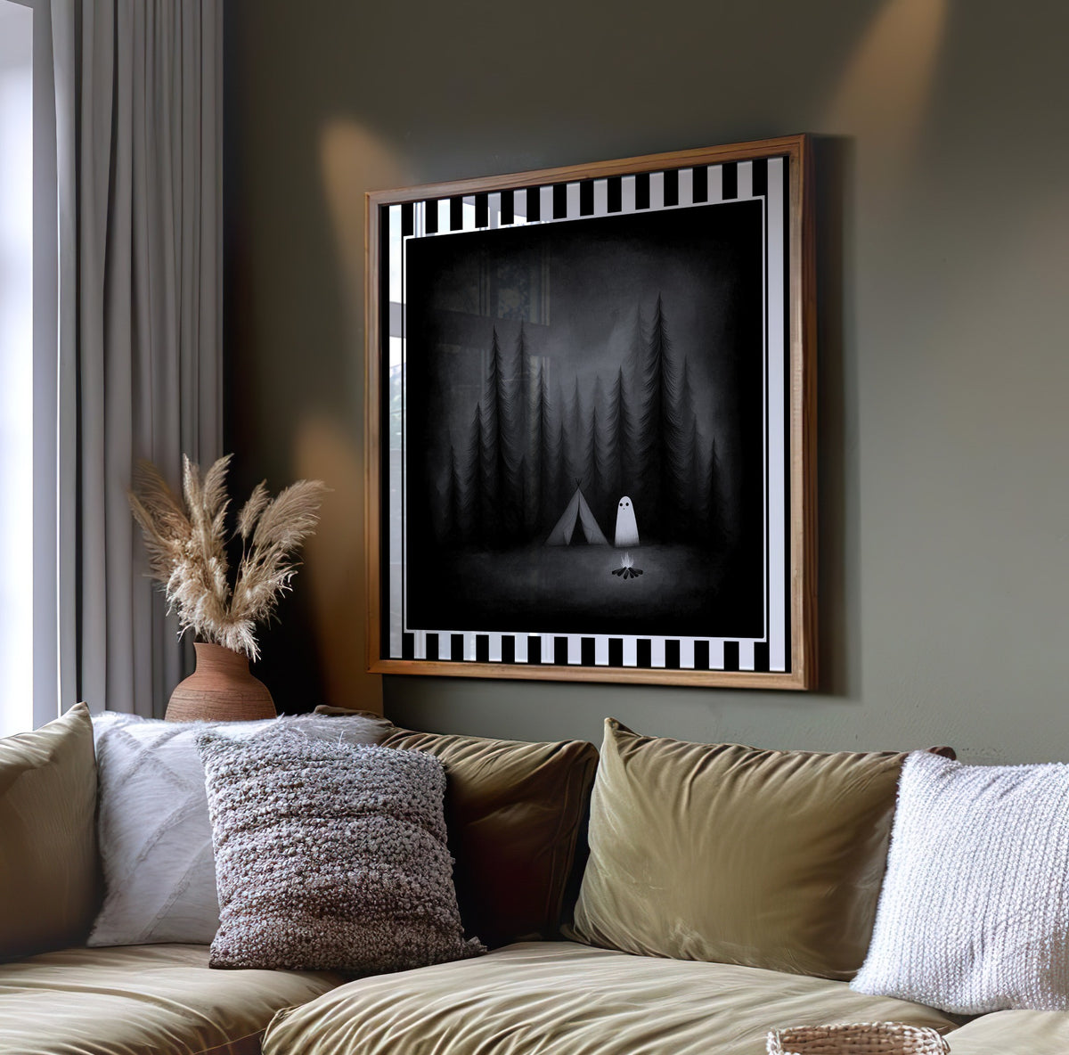 Ghost camping gothic print displayed in a light wood frame above a sofa