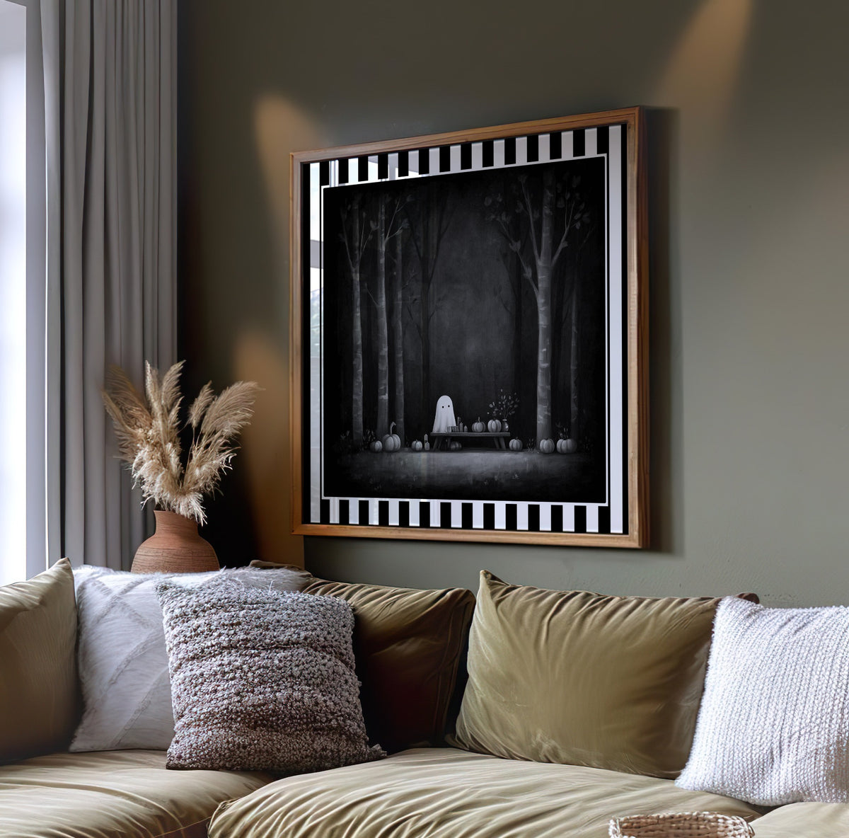 Ghost pumpkin picnic gothic print displayed in a light wood frame above a sofa