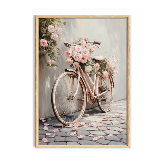 Vintage bicycle decorated with soft pink roses on a pale cobbled street.