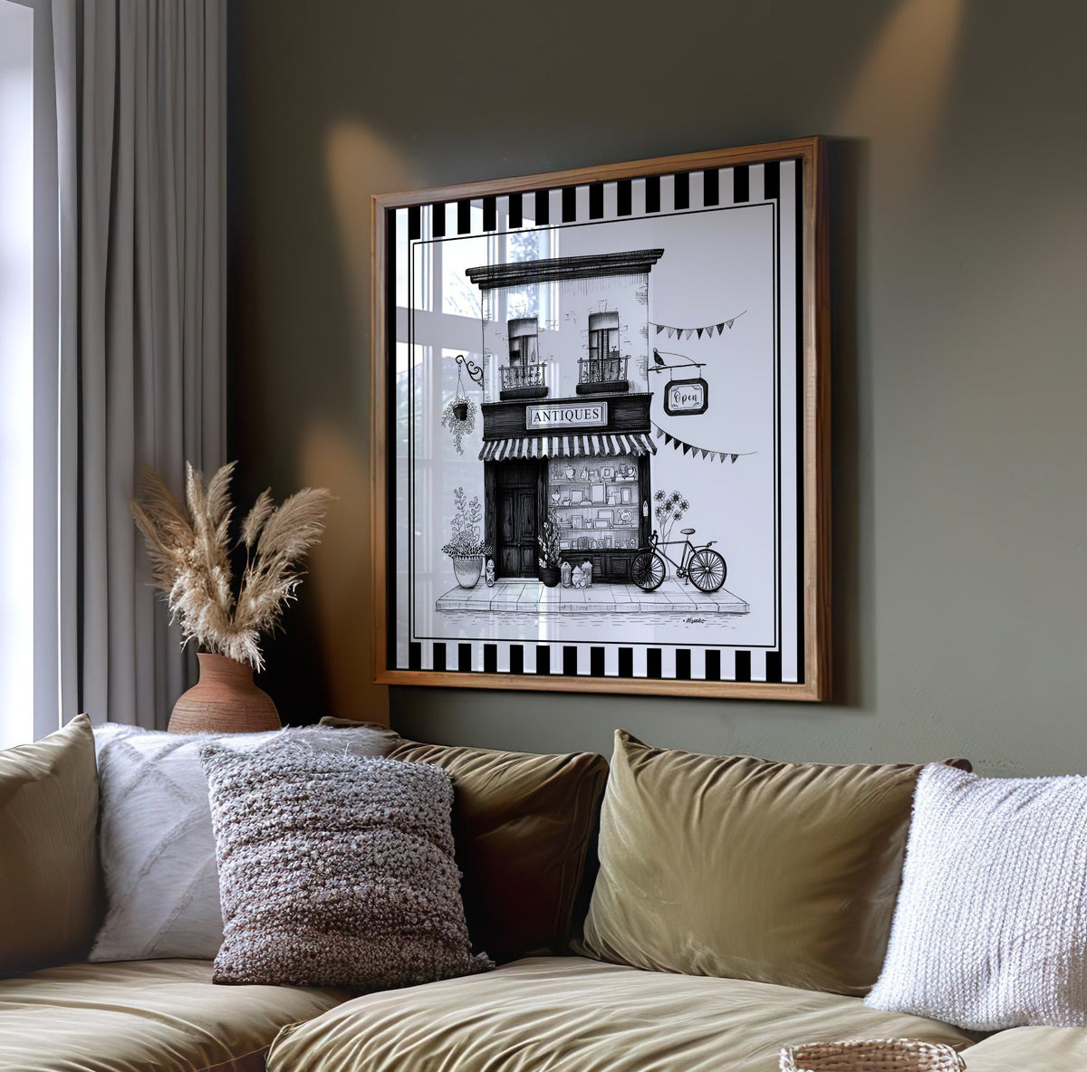 Black and white antique shop wall art displayed on a dark green wall above a sofa