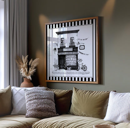 Black and white antique shop wall art displayed on a dark green wall above a sofa