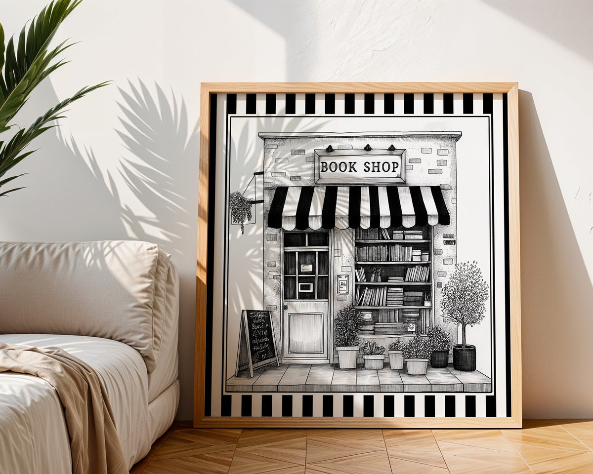 Black and white book shop print displayed in a light wood square frame beside a neutral sofa