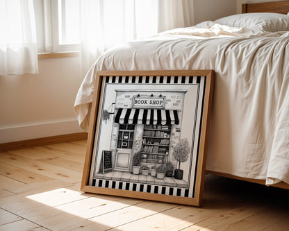 Black and white book shop print displayed beside a bed in a light wood square frame