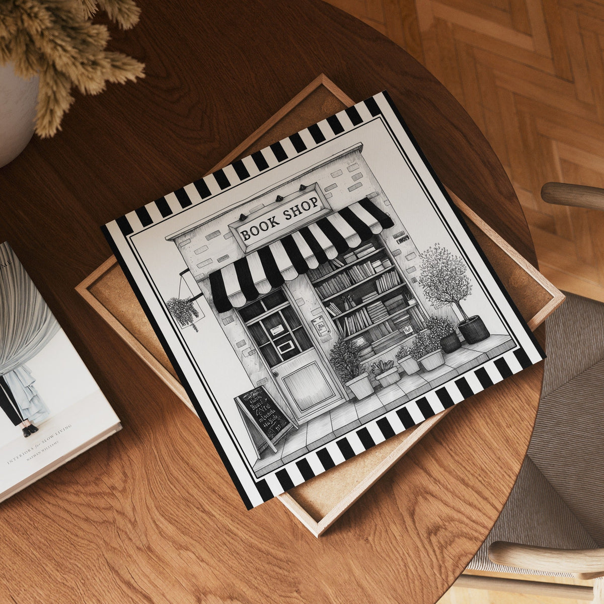 Square black and white book shop print displayed flat on a wooden table