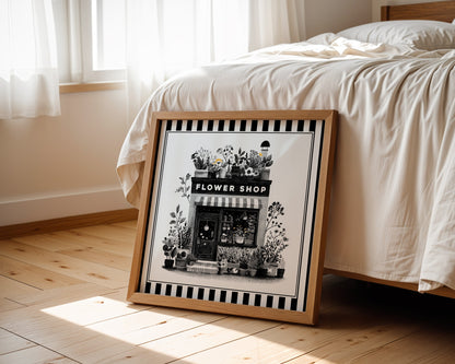 Black and white flower shop wall art displayed beside a bed in a light wood square frame