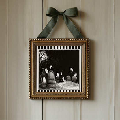 Ghost graveyard print displayed in an ornate gold square frame with ribbon