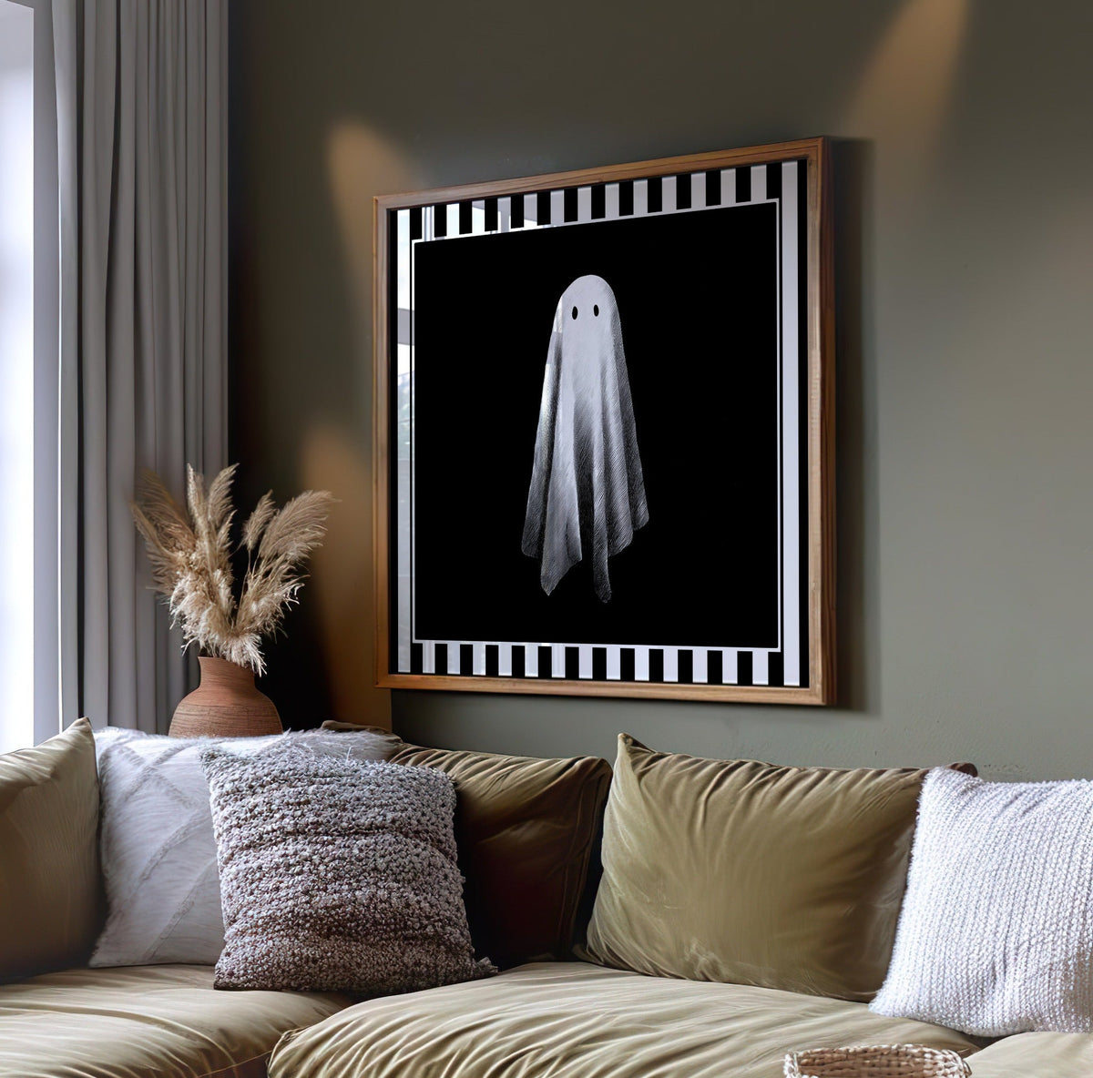 Single white ghost wall art displayed on a dark green wall above a sofa