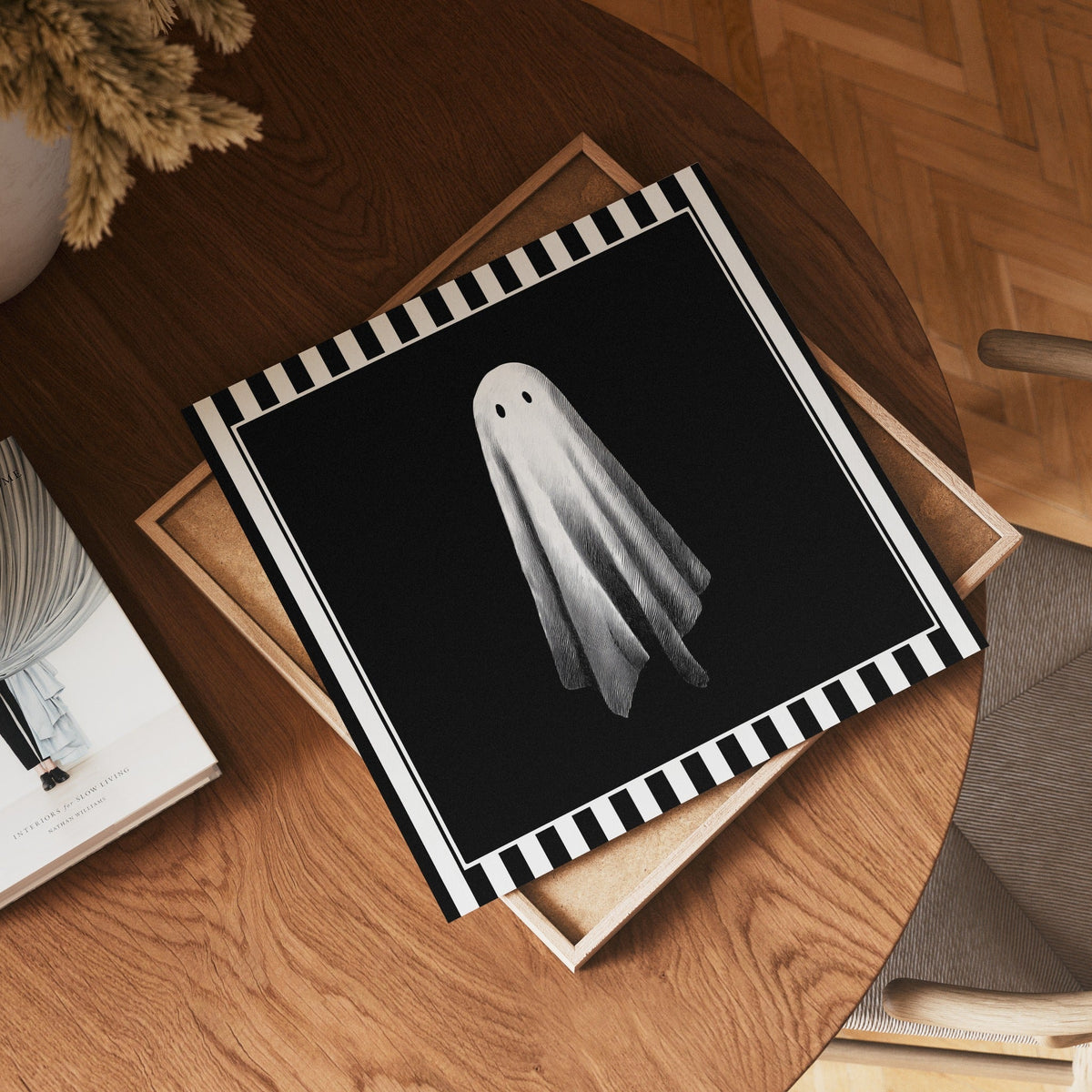 Square single white ghost print displayed flat on a wooden table