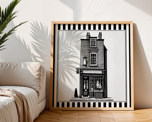 York ghost shopfront print displayed in a light wood square frame beside a neutral sofa