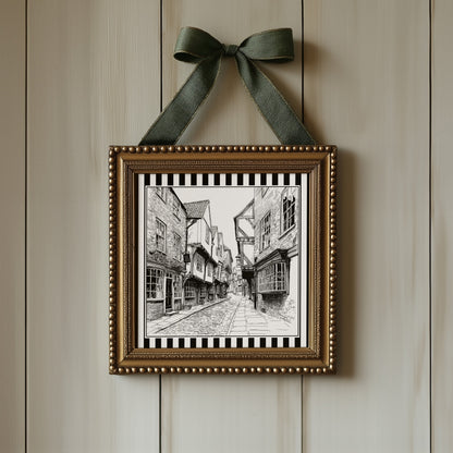 Black and white York Shambles street print displayed in an ornate gold square frame with ribbon