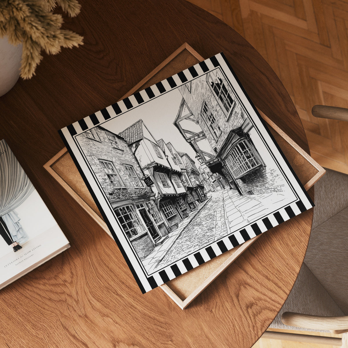 Square black and white York Shambles street print displayed flat on a wooden table