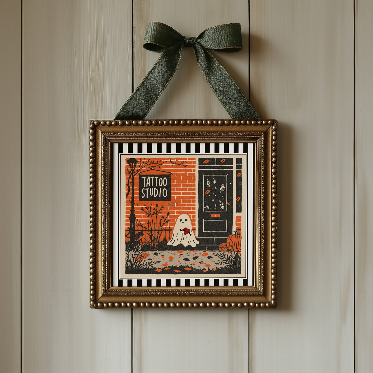 Tattoo studio ghost print displayed in an ornate gold square frame with ribbon