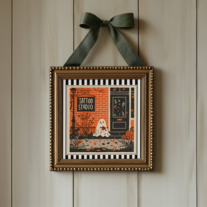 Tattoo studio ghost print displayed in an ornate gold square frame with ribbon