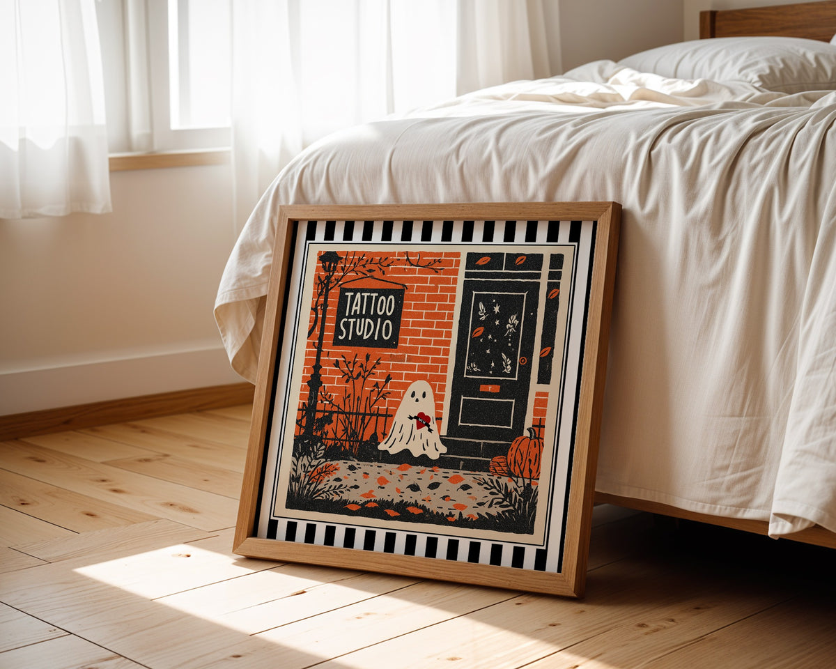Tattoo studio ghost print displayed beside a bed in a light wood square frame