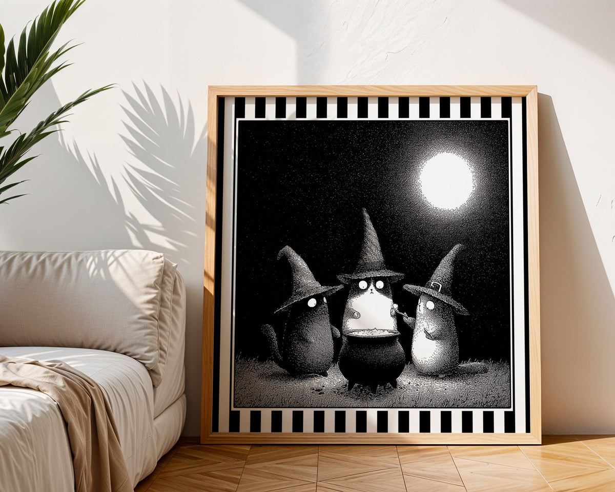 Witch cats moonlit print displayed in a light wood square frame beside a neutral sofa